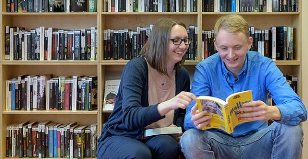 Die Stadt-Bücherei in Heidelberg: so viel verliehen wie noch nie (Foto: Rothe) Ein Mädchen und ein Junge sitzen vor einem Bücherregal und lesen in einem Buch (Foto: Rothe)