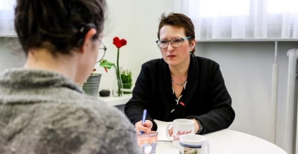Eine Frau sitzt mit dem Rücken zur Kamera am Tisch, ihr gegenüber die Kommunale Behindertenbeauftragte Christina Reiß Eine Frau sitzt mit dem Rücken zur Kamera am Tisch, ihr gegenüber die Kommunale Behindertenbeauftragte Christina Reiß