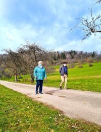 Zwei Spazierfreudige treffen sich mit Abstand und Maske, um gemeinsam die Natur zu genießen. (Foto: Sportkreis Heidelberg e.V.) Ein Senior und eine Seniorin beim Spazierengehen.