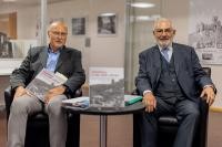 Dr. Peter Blum (l.), leitender Direktor des Stadtarchivs Heidelberg, und Wolfgang Erichson, Bürgermeister für Kultur, Bürgerdienste und Kreativwirtschaft, bei der Vorstellung des Bildbandes im Lesesaal des Stadtarchivs Heidelberg. (Foto: Stadt Heidelberg) Dr. Blum und Bürgermeister Erichson sitzen an einem Tisch. Darauf liegt der neue Bildband.
