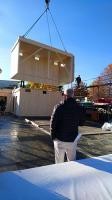 Ein Autokran setzt die schlüsselfertigen Holzmodule der Kita Breisacher Weg an ihren Platz. Hochbauamtsleiter Harald Heußer beobachtet die Anlieferung der Küche. (Foto: Stadt Heidelberg) Hochbauamtsleiter Heußer von hinten, wie er beobachtet, wie ein Holzmodul von einem Kran abgesenkt wird.