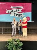 Oberbürgermeister Prof. Dr. Eckart Würzner zieht die Gewinner der Bürgerfest-Rallye am Ende der Veranstaltung. (Foto: Stadt HD) Foto von Bürgermeister auf einer Bühne