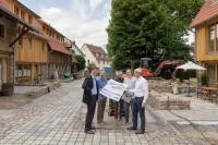 Miteigentümer und Architekt Thomas Kochhan erklärt Erstem Bürgermeister Jürgen Odszuck die aufwendigen Planungen und detailreichen Umbauarbeiten auf dem Grundstück (v.l.n.r.: Erster Bürgermeister Jürgen Odszuck, Amtsleiter für Baurecht und Denkmalschutz der Stadt Heidelberg Jörg Hornung, Mitarbeiter des zuständigen Architektenbüros Conrad Wuhrer, Thomas Apfel, Denkmalschutzexperte der Stadt Heidelberg und Thomas Kochhan, Architekt und Bauherr) (Foto: Philipp Rothe) Menschen halten ein Plakat in den Händen