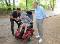 Turan Ala (v.l.) von Sunrise Medical erklärt Alexander und Oberbürgermeister Prof. Dr. Eckart Würzner die Funktionen des Geländerollstuhls. (Foto: Stadt Heidelberg) Ein Junge sitzt im Geländerollstuhl und bekommt die Funktionen erklärt