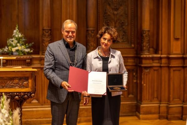Oberbürgermeister Prof. Dr. Eckart Würzner überreichte EMBL-Generaldirektorin Prof. Dr. Edith Heard im Großen Rathaussaal die Richard-Benz-Medaille der Stadt Heidelberg. (Foto: Tobias Dittmer) Ein Mann und eine Frau stehen nebeneinander mit der Medaille und einer Urkunde in der Hand