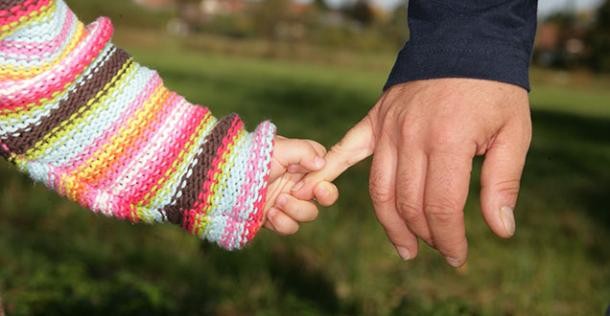 Kinder- und Erwachsenenhand (Foto: Shutterstock) Kinderhand hält sich an Erwachsenenhand fest