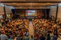 Heidelbergs Klimabürgermeister Raoul Schmidt-Lamontain begrüßte die Teilnehmenden der städtischen Infoveranstaltung „Bügerwindpark Lammerskopf“. Rund 350 Besucherinnen und Besucher tauschten sich in der Steinbachhalle in Ziegelhausen mit externen Experten über verschieden Aspekte eines möglichen Windparks aus. Rund 350 Besucherinnen und Besucher in einer Halle