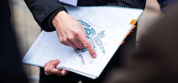 Fragen zum Thema Wohnen und Bauen beantwortet das Technische Bürgeramt (Foto: Dittmer) Mensch mit Bebauungsplan in der Hand