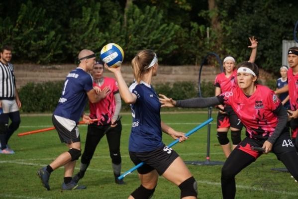 Quidditch ist eine Mischung aus Handball, Dodgeball und Rugby – die Heidelberger HellHounds vom Quidditch Heidelberg e. V. möchten Interessierten am 27. Mai 2024 ihre Sportart im Rahmen der „Sport im Park“-Spezialkurse näherbringen. Zwei Teams, die gegenseitig auf Besen sich einen Ball zuwerfen.