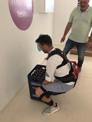 Handwerker Denis Waskey hebt mit Unterstützung des Exoskeletts gleich zwei Getränkekästen. (Foto: Stadt Heidelberg) Handwerker Denis Waskey hebt mit Unterstützung des Exoskeletts gleich zwei Getränkekästen.