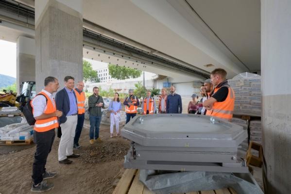 Die Montpellierbrücke erhält neue Brückenlager (vorn im Bild). Das sind Gelenke zur Übertragung der Kräfte eines Tragwerks auf den Unterbau, beispielsweise die Pfeiler. Bülent Kardogan (l.) vom Tiefbauamt gab Erstem Bürgermeister Jürgen Odszuck (2.v.l.) bei der Baustellentour einen Überblick über die laufenden Arbeiten. Mehrere Menschen stehen unter einer Brücke
