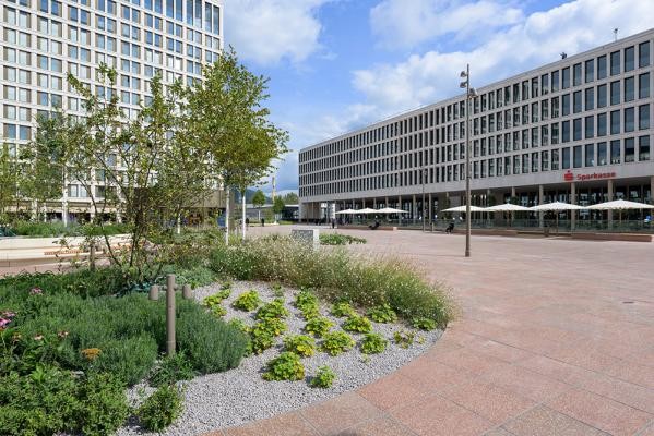 Mit rund 8.800 Quadratmetern bietet der Europaplatz viel Aufenthaltsqualität. (Foto: Philipp Rothe) Ein moderner Platz mit modernen Gebäuden und grünen Inseln ist zu sehen