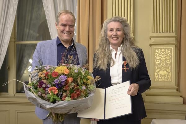 Oberbürgermeister Eckart Würzner überreichte Dr. Karin Werner-Jensen am Mittwoch, 16. Oktober 2024, im Prinz Carl das Bundesverdienstkreuz. (Foto: Rothe) Ein Mann und eine Frau stehen in einem festlichen Saal mit Urkunde und Blumenstrauß.