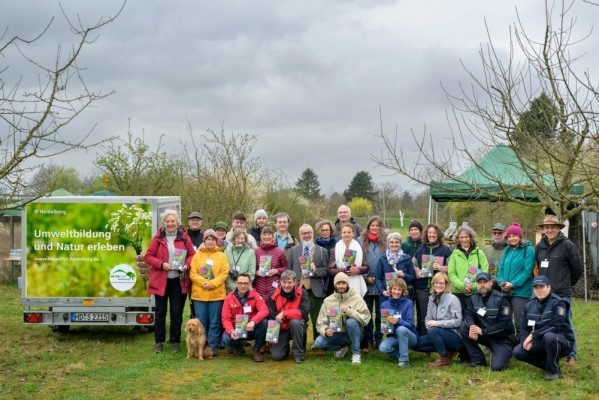 Rund 30 Teilnehmerinnen und Teilnehmer waren bei der Programmeröffnung „Natürlich Heidelberg 2025“ im „Garten für alle“ des Obst- und Gartenbauvereins Heidelberg-Kirchheim mit dabei.(Foto: Rothe) Gruppenfoto auf einer grünen Wiese mit Bäumen.