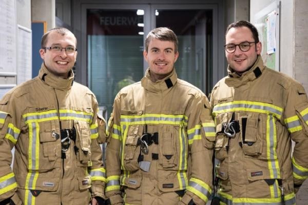 Das neue Stadtbrandmeisterteam: Alexander Stadler (Mitte) mit seinen Stellvertretern Daniel Gärtner (links) und Samuel Scherer (Foto: Stadt Heidelberg) Drei Männer lächeln in Feuerwehr-Einsatzkleidung in die Kamera.