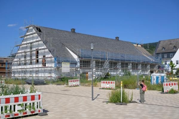 Ein bogenförmiges Holzbinder-Satteldach und historische Holzsprossenfenster prägen das Erscheinungsbild des Mauerwerksgebäudes. Große Teile der Halle stehen unter Denkmalschutz. (Foto: Philipp Rothe) Die künftige Beachhalle mit Baugerüst in der Außenansicht.