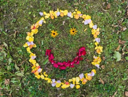 Mehr Lebensfreude: Wie man die im Alter erlangen kann, zeigt ein Kurs im Seniorenzentrum Weststadt/Südstadt ab 7. Oktober. (Foto: Stadt Heidelberg) Auf einer grünen Wiese ist ein Smiley aus Blumen und Blütenblättern gelegt. Der Kopf besteht aus gelben und hell-lila Blütenblättern, der Mund aus rot-pinken Blütenblättern und die Augen bestehen aus zwei gelben Blüten.