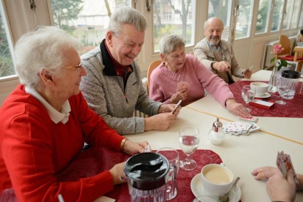Gemeinsam spielen tut gut: In den Heidelberger Seniorenzentren gibt es regelmäßig Aktivitäten, die Einsamkeit vorbeugen. (Foto: Nicolaus Niebylski) Seniorinnen und Senioren sitzen gemeinsam an einem Tisch und spielen