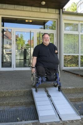 Ein Rollstuhlfahrer verlässt über eine mobile Rampe ein Gebäude. (Foto: Philipp Rothe) Ein Rollstuhlfahrer nutzt eine mobile Rampe