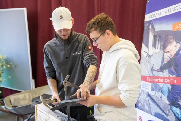 Bei den Ausbildungstagen konnte man auch selbst Dinge ausprobieren. (Foto: Buck) Zwei Männer beugen sich über ein Schieferstück.