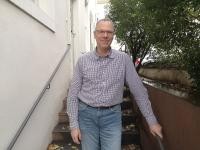 Jan Kotulla ist Ansprechpartner in der Abteilung Unternehmensservice und Standortentwicklung. (Foto: Stadt Heidelberg) Jan Kotulla steht auf einer Treppe vor dem Haus der Wirtschaftsförderung und lächelt in die Kamera.