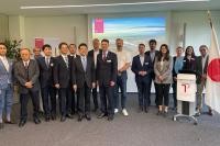 Die Delegation aus Kumamoto war auch im Business Development Center zu Gast. (Foto: Stadt Heidelberg) Eine Gruppe von Menschen steht in einem Raum vor einer Leinwand zum Gruppenfoto.