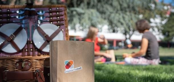 Freiwillige beim Picknick (Foto: C. Buck) Zwei Menschen auf grüner Wiese beim Picknick
