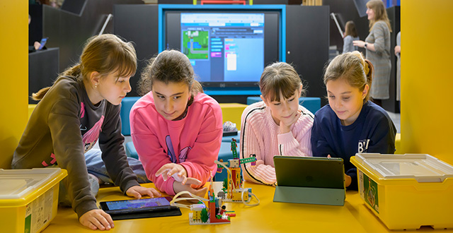 vier Kinder an digitalen Geräten 