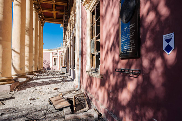 Gang entlang eines alten Gebäudes mit Trümmern.