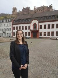 Porträtfoto von Ann-Kathrin Riedel vor dem Heidelberger Schloss.