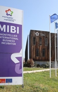 Ein Schild steht vor einem Gebäude mit Holzfassade. Es ist beschriftet mit "Montpellier International Business Incubator".